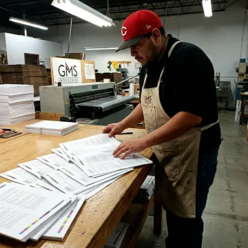 Folded instruction sheets being checked during print finishing