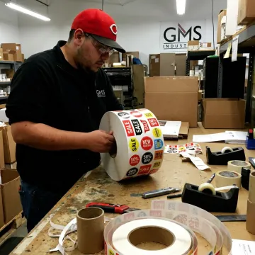 Technician inspecting printed retail label rolls