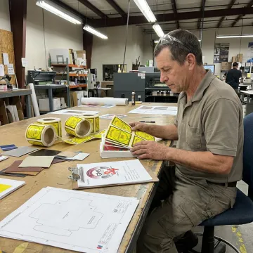 Technician reviewing custom die cut label proofs