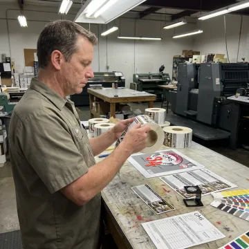 Technician reviewing rolls of apparel labels