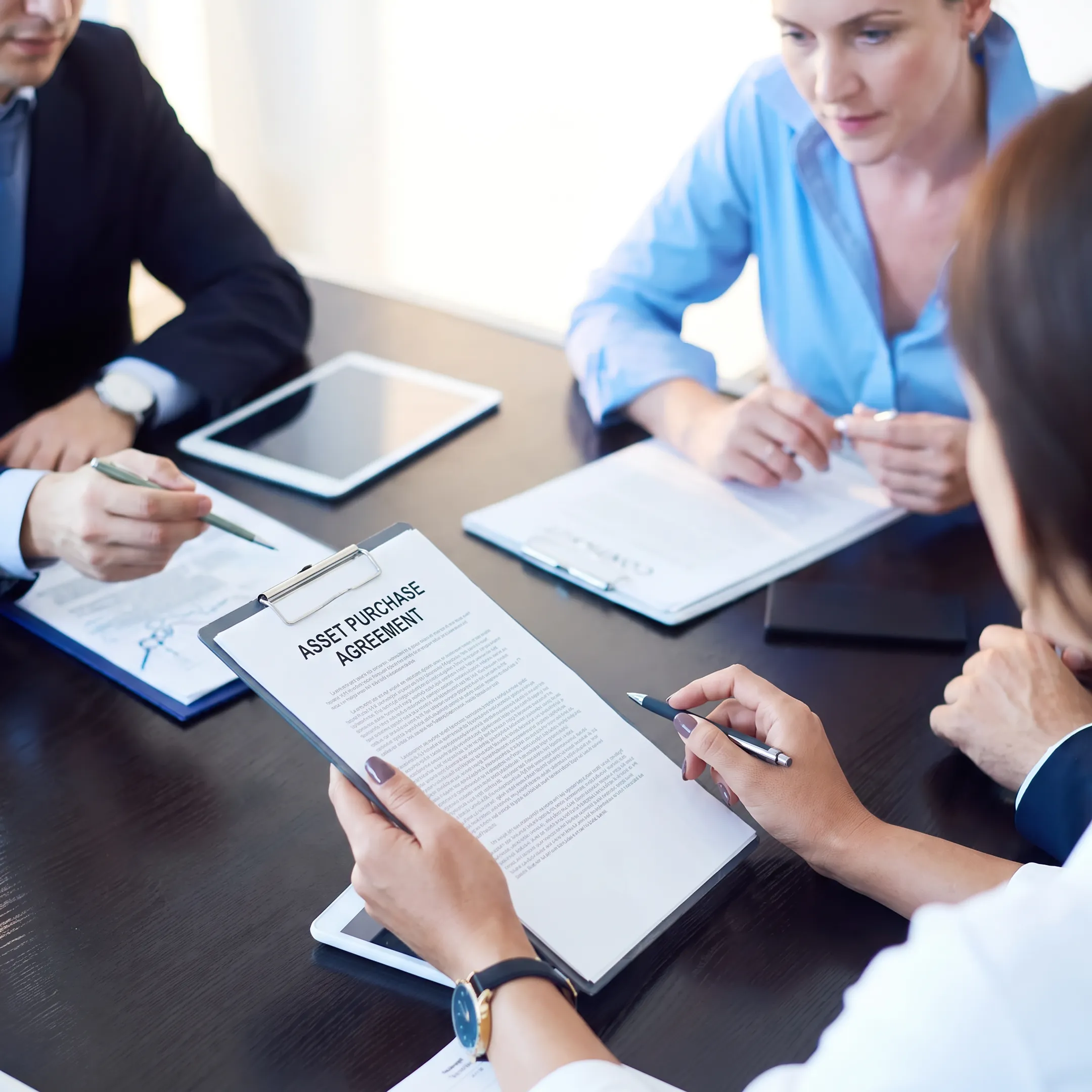 Florida business attorney discussing an asset acquisition agreement with clients