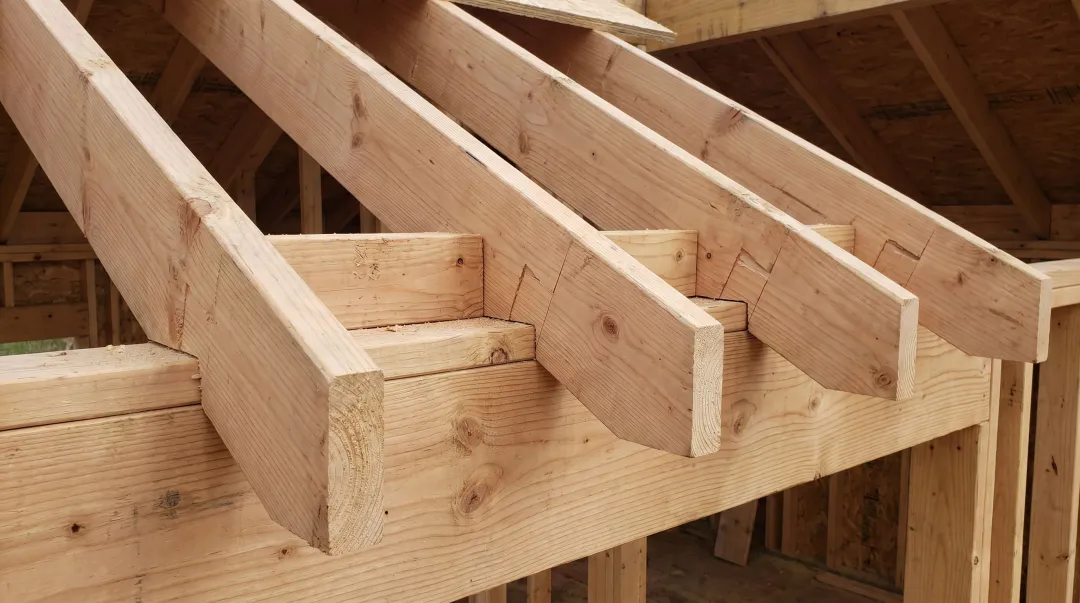 Roof rafter framing with bird's mouth cuts installed on header beam