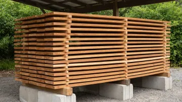 Cedar siding boards stored flat off ground with stickers for proper acclimation airflow