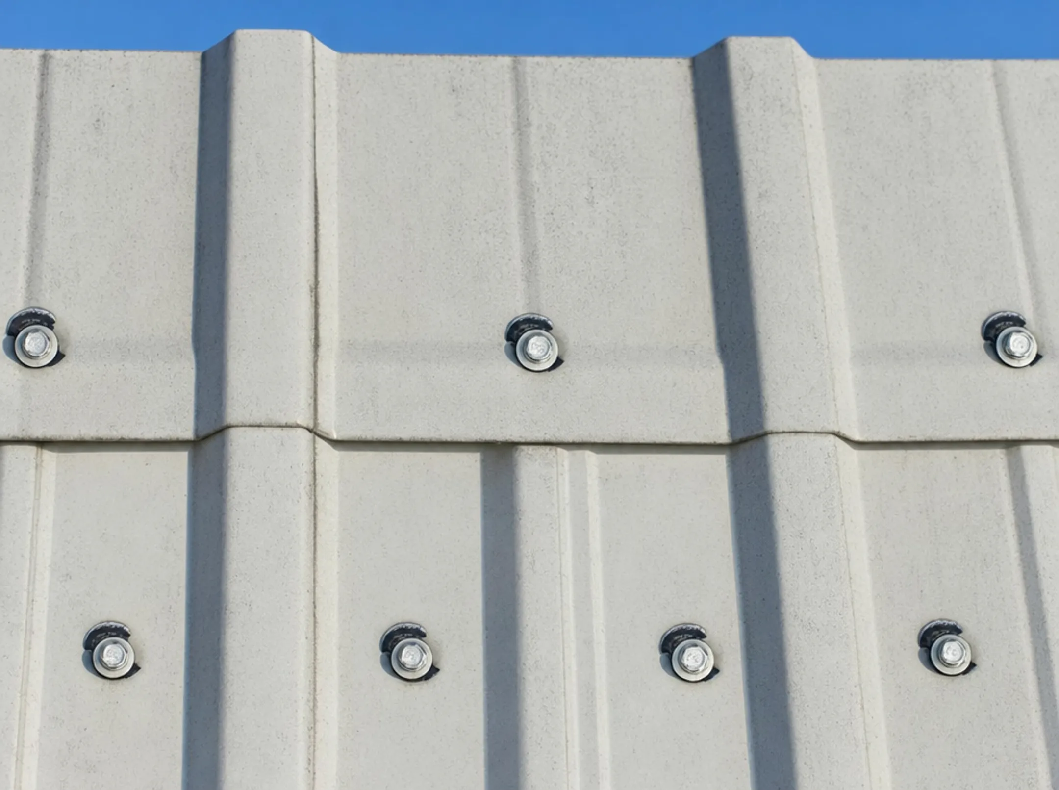 Exposed fastener metal roof panels with visible screw heads close-up