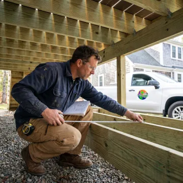 Contractor inspecting under deck waterproofing