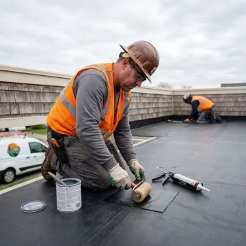 Contractor applying a flat roof membrane repair