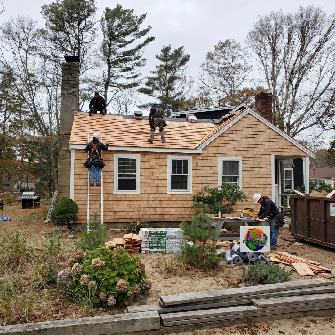Roofing and siding contractors working on a coastal home