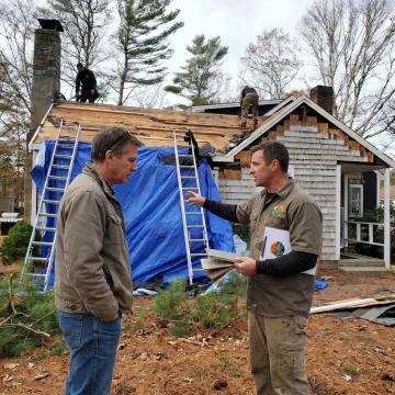 Contractor inspecting roof and siding materials
