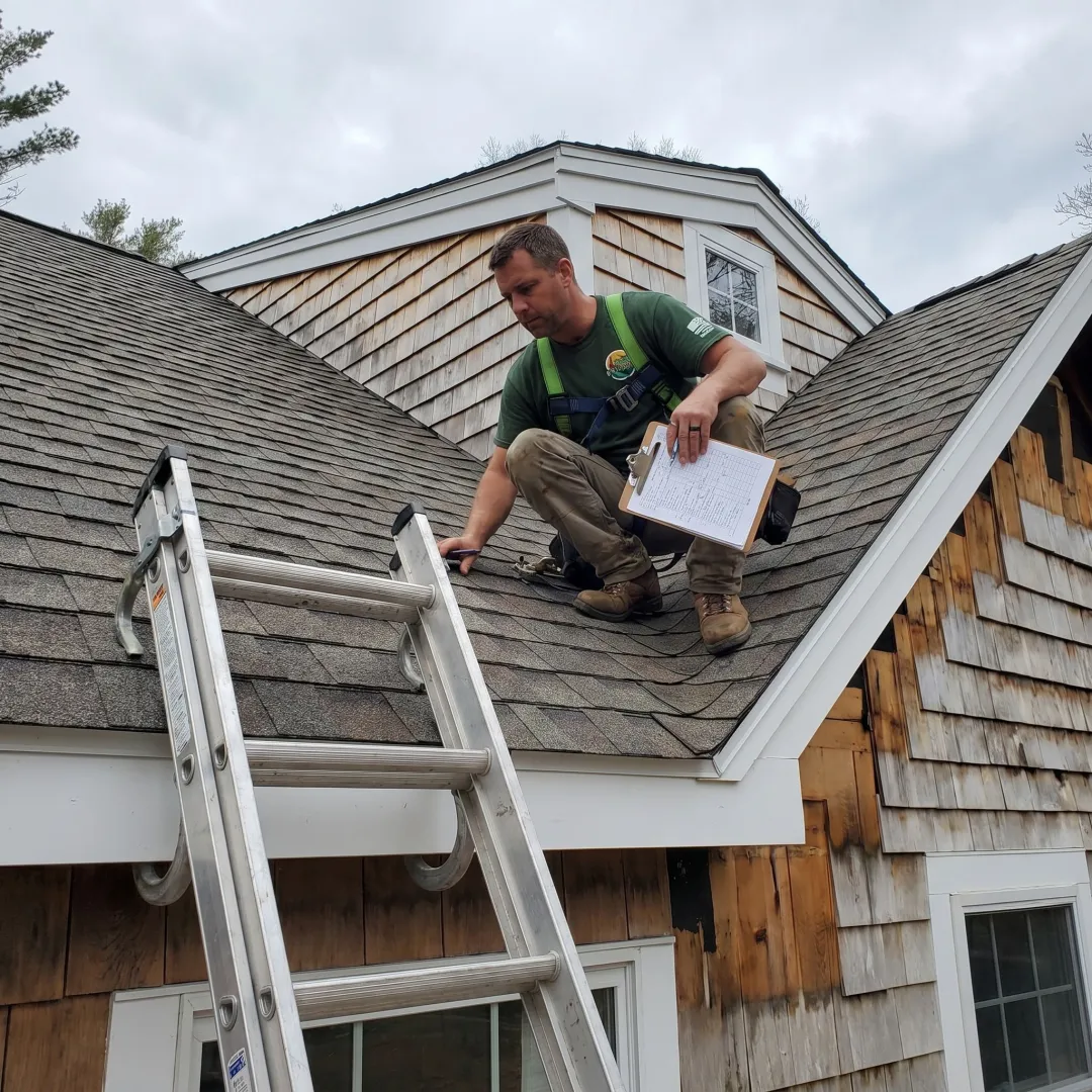 Roofing contractor inspecting shingles before roof repair