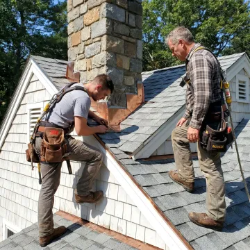 Roofing contractor inspecting residential roof