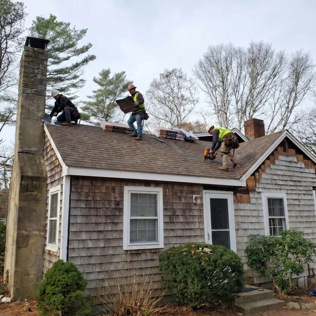 Roofing crew replacing shingles on a residential home