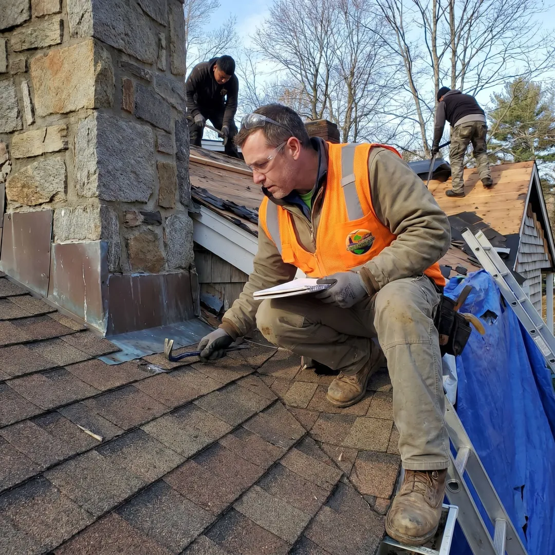 Roofing contractor inspecting shingles on a home