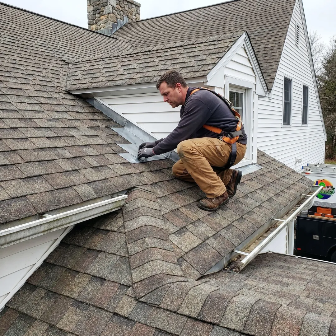 Roofing contractor inspecting shingles and flashing