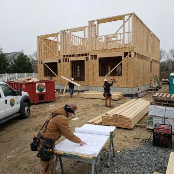 Custom home construction site with builders reviewing plans