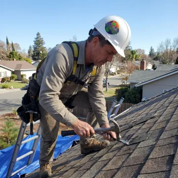 Roofer repairing shingles on a Fairfield home
