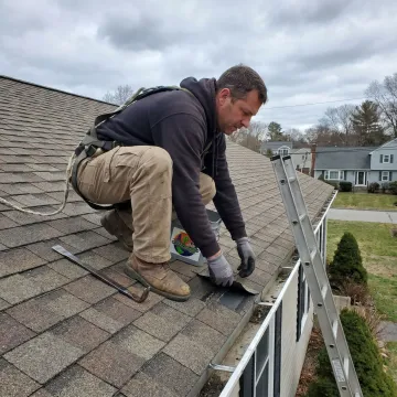 Residential roof repair contractor inspecting shingles