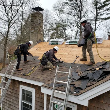 Roof repair team completing shingle repairs