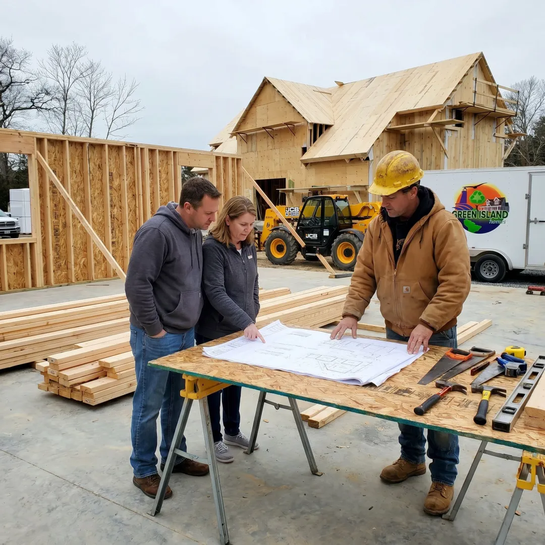 Builder reviewing custom home plans on site