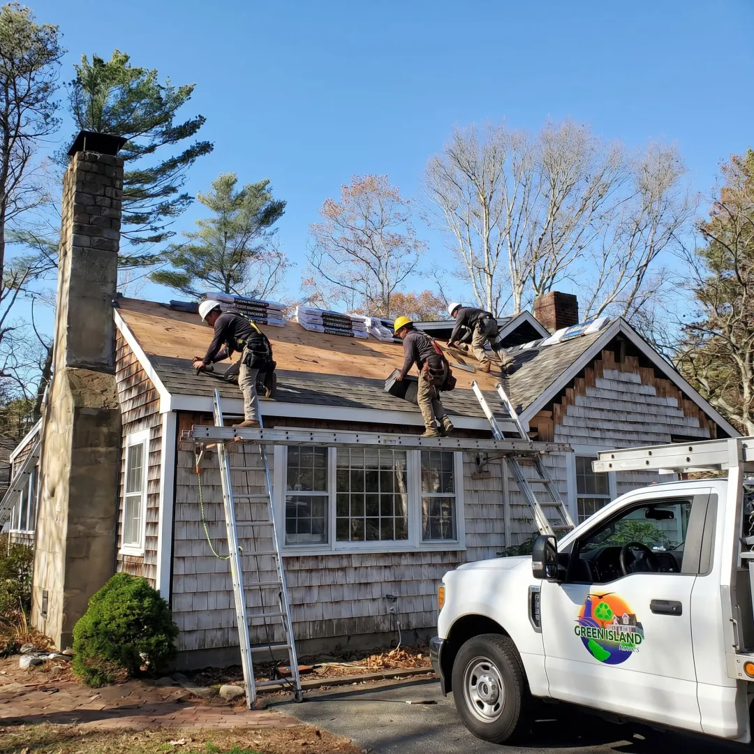 Residential roofing crew installing shingles on a home