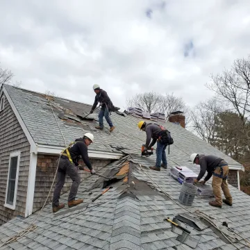 Roof repair crew working on storm damaged home