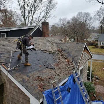 Contractor inspecting storm damaged roof in Louisville