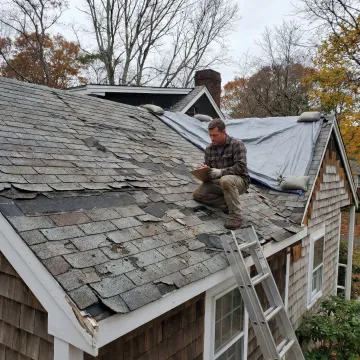 Roofing contractor documenting hail and wind damage
