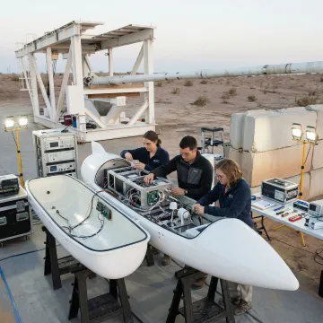 Scientists preparing atmospheric sampling payload for launch with technical equipment