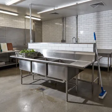 Stainless steel food processing sink in a commercial facility