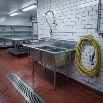 Stainless steel sink in a meat processing workspace