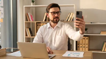 Person filming authentic behind-the-scenes business video on smartphone for social media