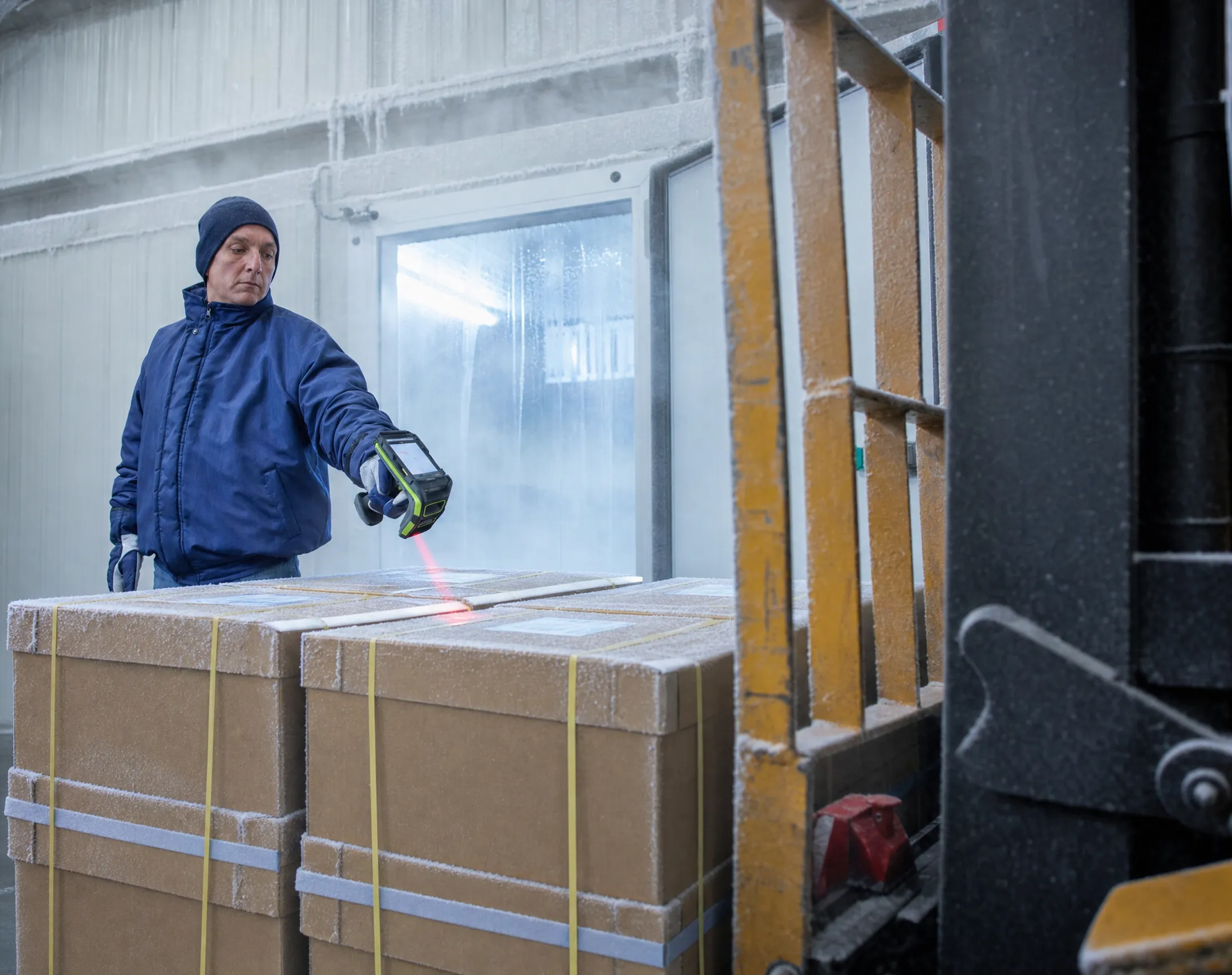 Cold storage warehouse worker scanning inventory with rugged handheld device