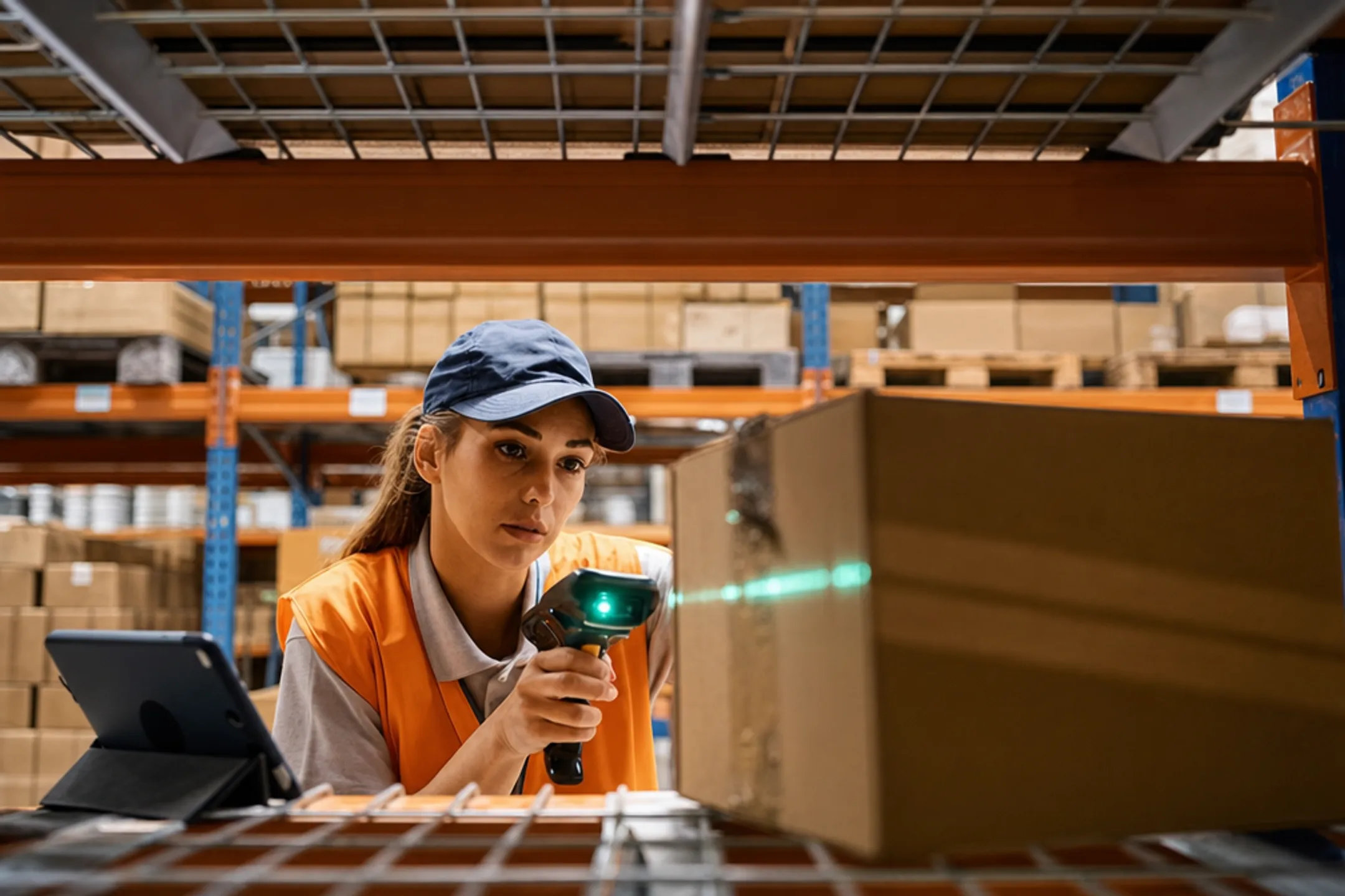 Warehouse worker using handheld barcode scanner for inventory tracking
