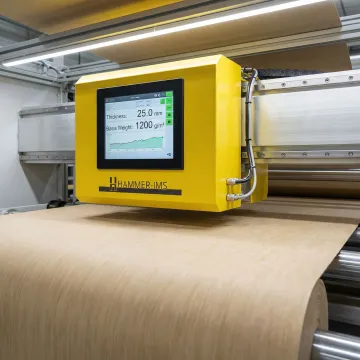 Close-up of M-Ray measurement sensor scanning material on production line