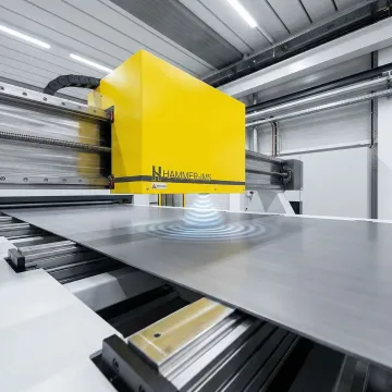Non-contact thickness measurement sensor scanning a flat plastic sheet on an industrial production line