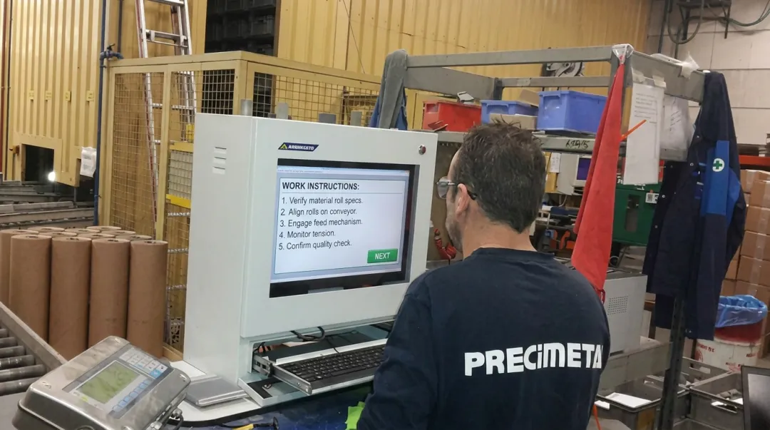 Manufacturing operator referencing digital work instructions on shop floor terminal