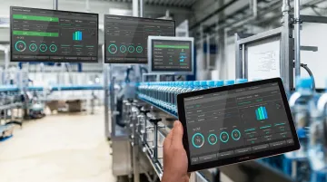 Shop floor manufacturing facility with large-format dashboard displays and workstation screens