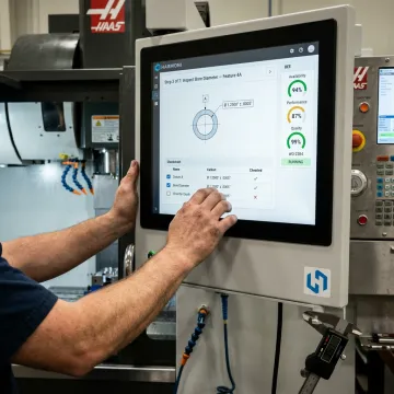 Digital checklist displayed beside manufacturing equipment