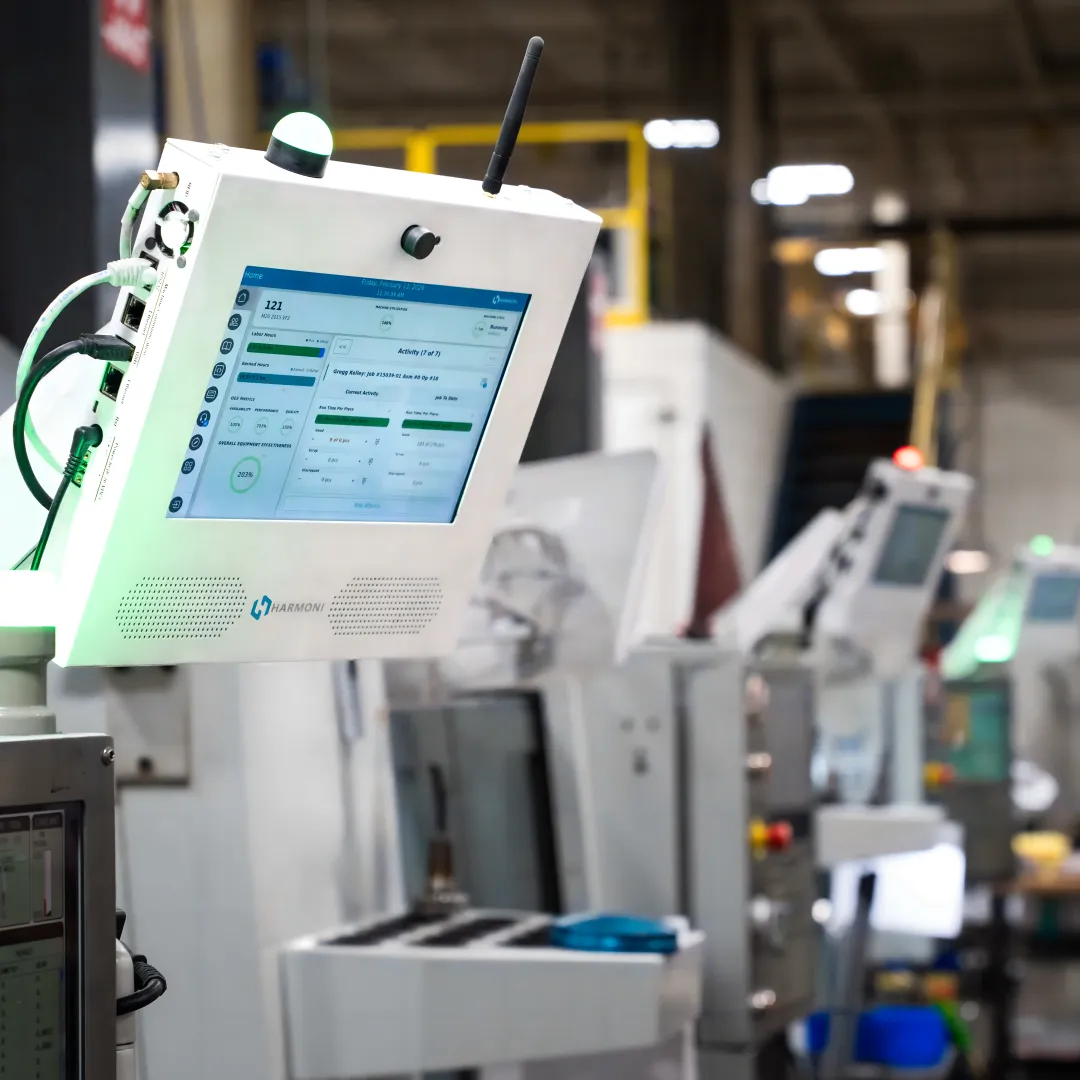 Operator reviewing machine uptime data at a CNC workcenter