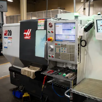 Operator reviewing downtime data at a CNC machine