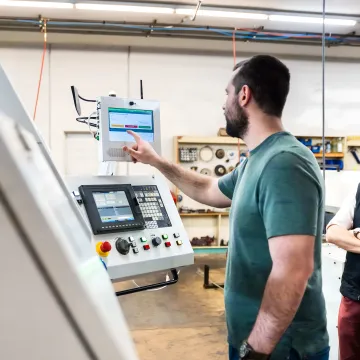Digital checklist displayed beside manufacturing equipment