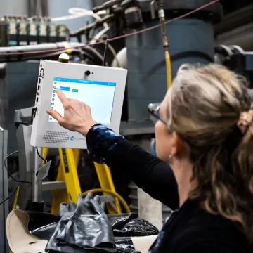 CNC operator using Harmoni software at a machine