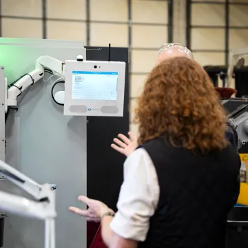 Operator reviewing real-time manufacturing dashboard at CNC machine