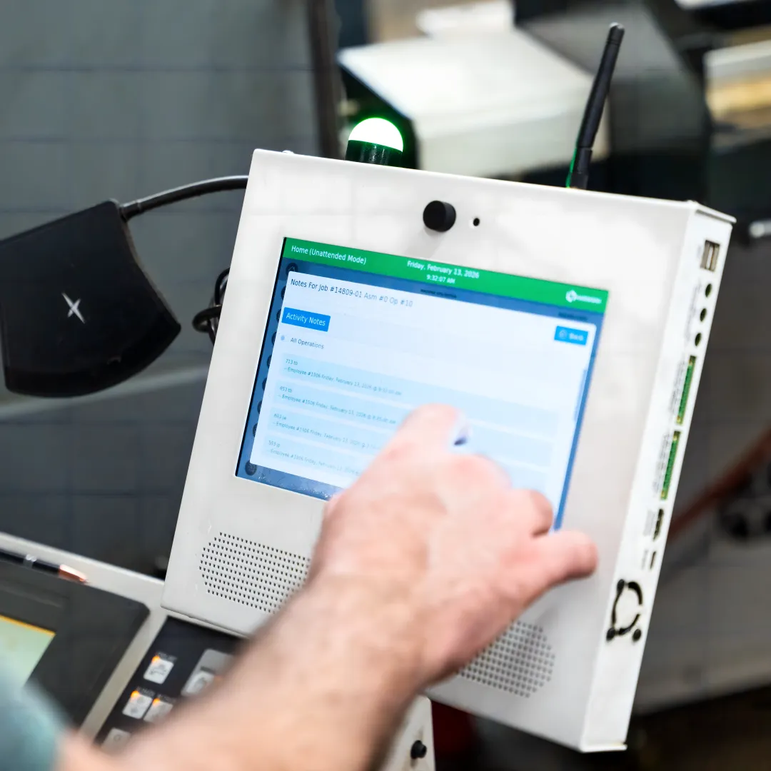 Operator using shop floor management software at CNC machine