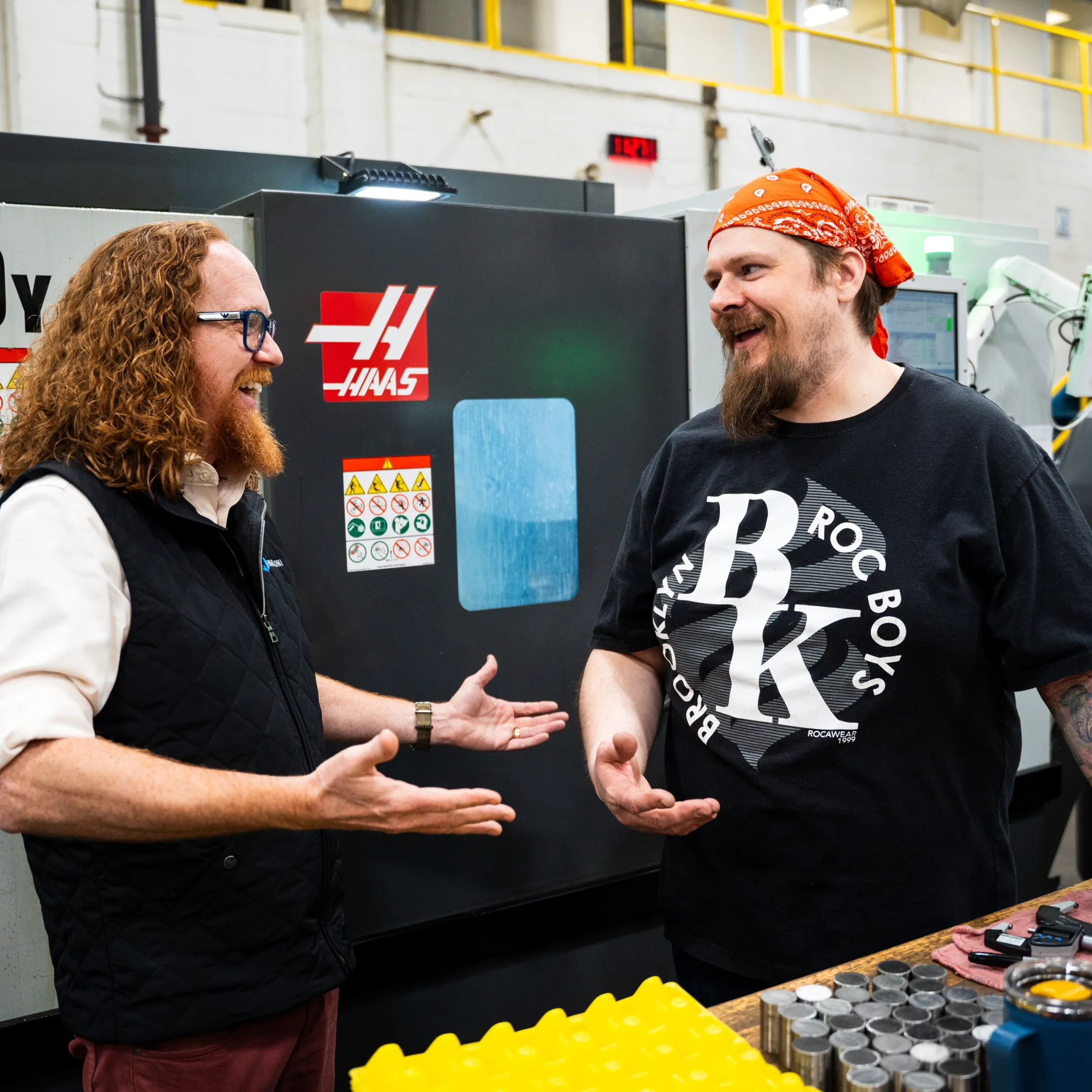 Operator reviewing digital production instructions beside a CNC machine