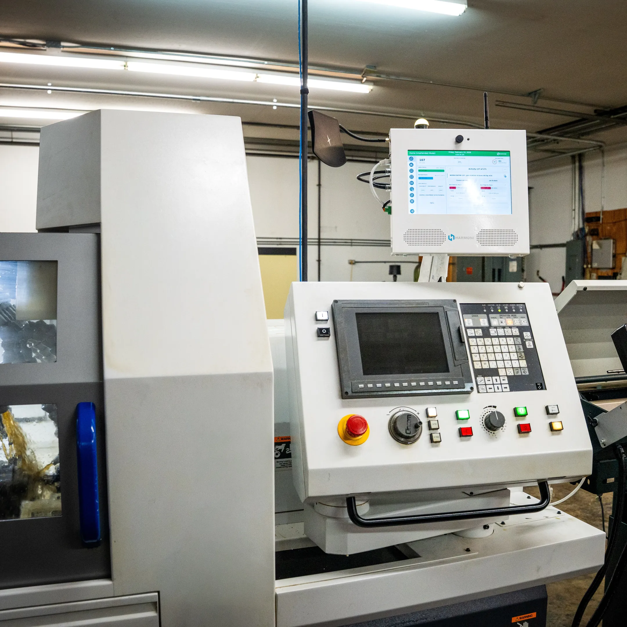 Digital work order details displayed beside a CNC machine