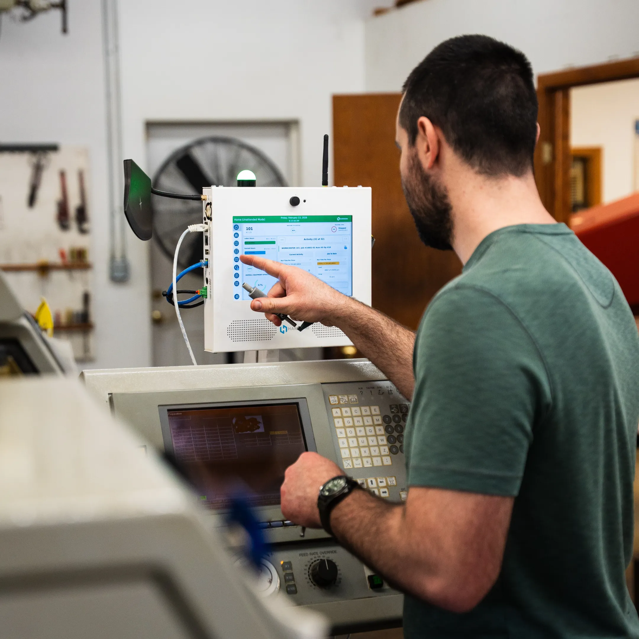 Operator completing a digital inspection checksheet at a CNC machine