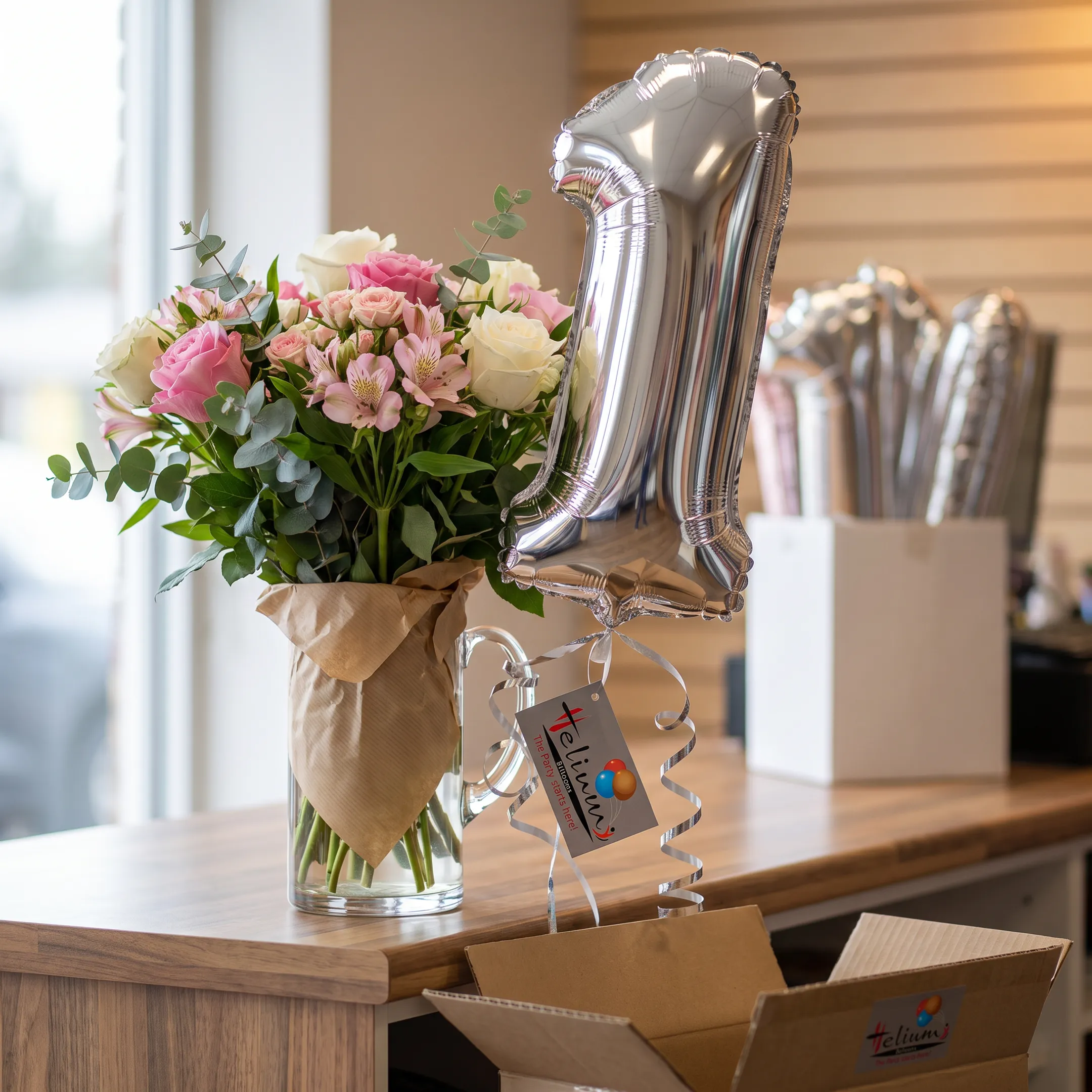 A flower bouquet complemented by a silver foil number balloon.