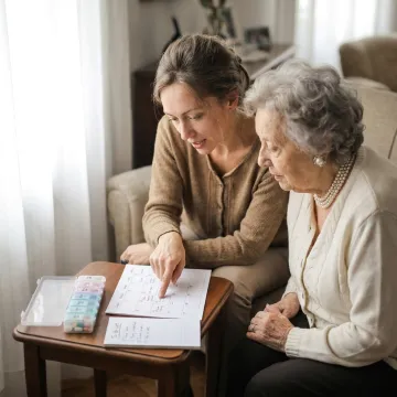 Personal assistant helping an elderly adult at home