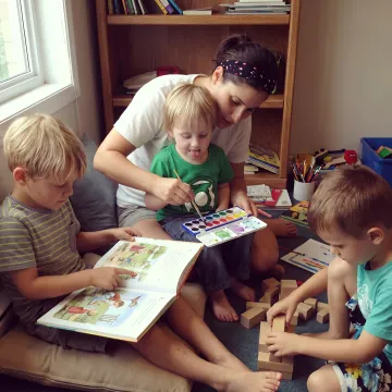Caregiver leading children in a creative enrichment activity