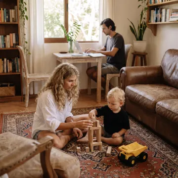 Caregiver playing with child while parent works